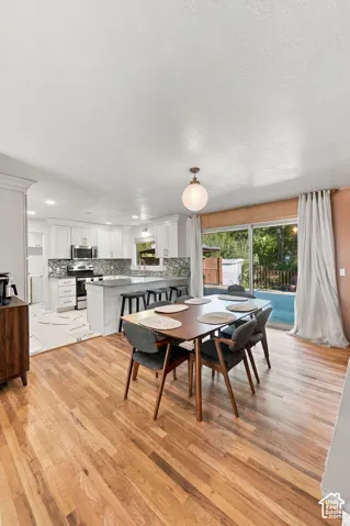 Spacious kitchen with white cabinetry, stone countertops, and tile backsplash