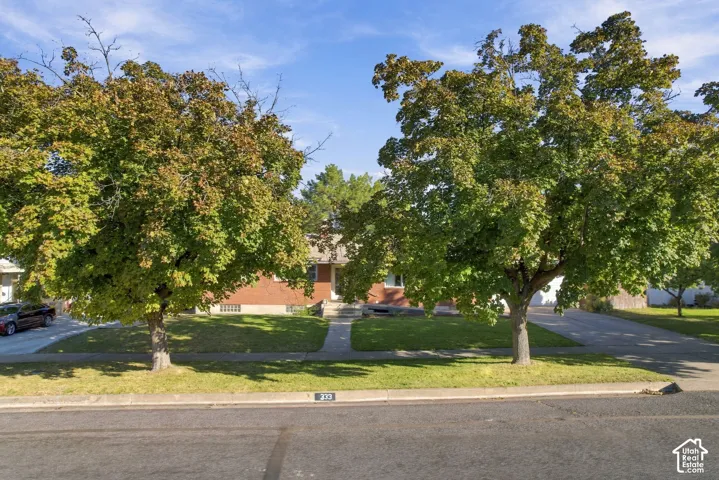 Brick exterior with a mature tree-lined front yard