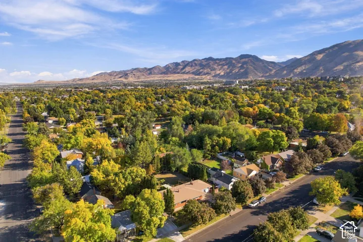Expansive residential area featuring established homes, mature trees, and mountainous terrain