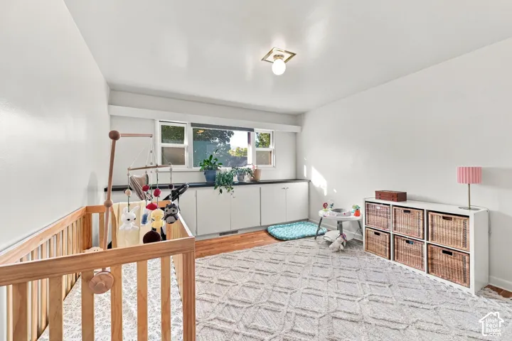 Hardwood flooring, built-in cabinetry with dark countertops, built-in shelving, and a flush mount ceiling light