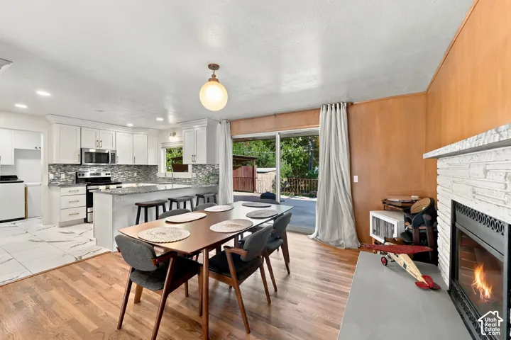 Bright kitchen with white cabinetry, stainless steel appliances, and a mosaic tile backsplash