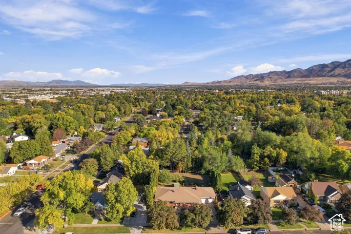 Expansive residential area with abundant mature trees and distant mountain ranges