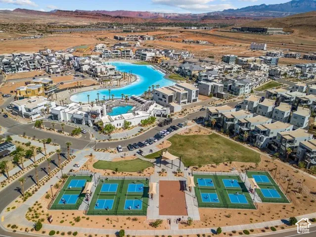 Expansive community featuring a large recreational lagoon, multiple sports courts, and contemporary residential structures