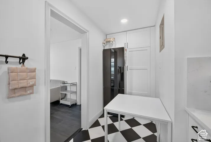 Black and white checkered flooring, white cabinetry, integrated refrigerator, recessed lighting, white countertops