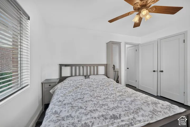 Wood-finish ceiling fan with integrated lighting, multiple paneled doors, and a window with horizontal blinds
