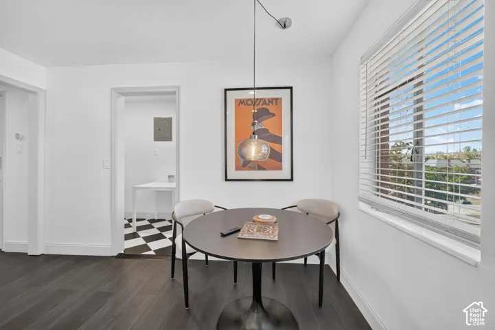 Wood-finish flooring, white walls, and a large window with horizontal blinds