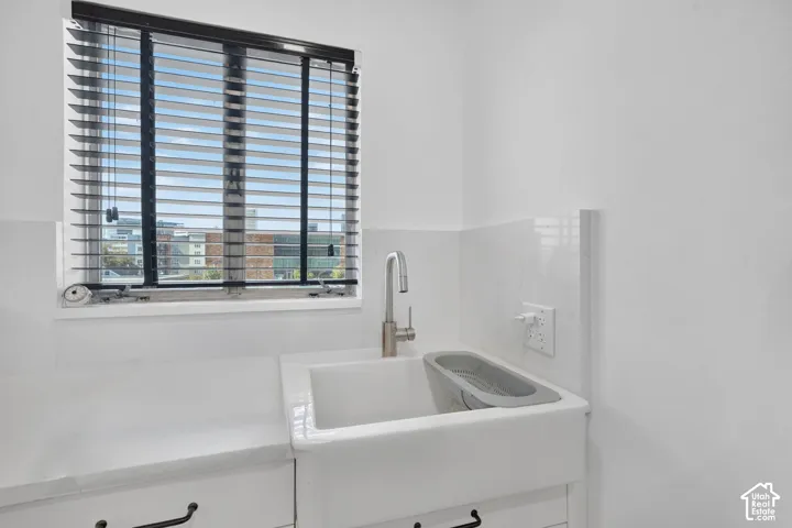 White farmhouse-style sink with a stainless steel faucet, set into a white countertop