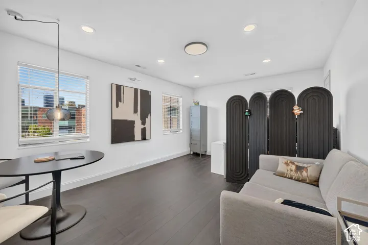 Recessed lighting, wood-finish flooring, multiple windows with blinds, and contemporary pendant lighting