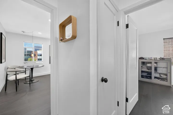 Dark wood-finish flooring throughout, white walls, and white trim