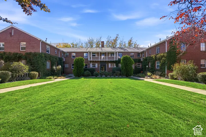 Brick exterior with white trim, featuring a central balcony