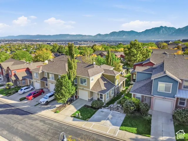 Mountain backdrop, residential street, attached garages, mature trees, landscaped grounds