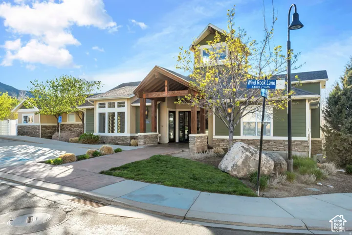 Exterior facade featuring timber-framed entry, stacked stone accents, horizontal siding, and a central cupola