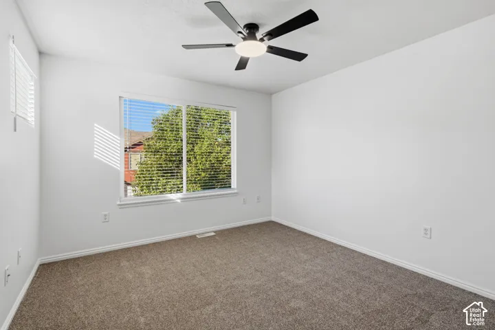 Recessed window with white blinds, neutral carpeting, and a ceiling fan with integrated lighting