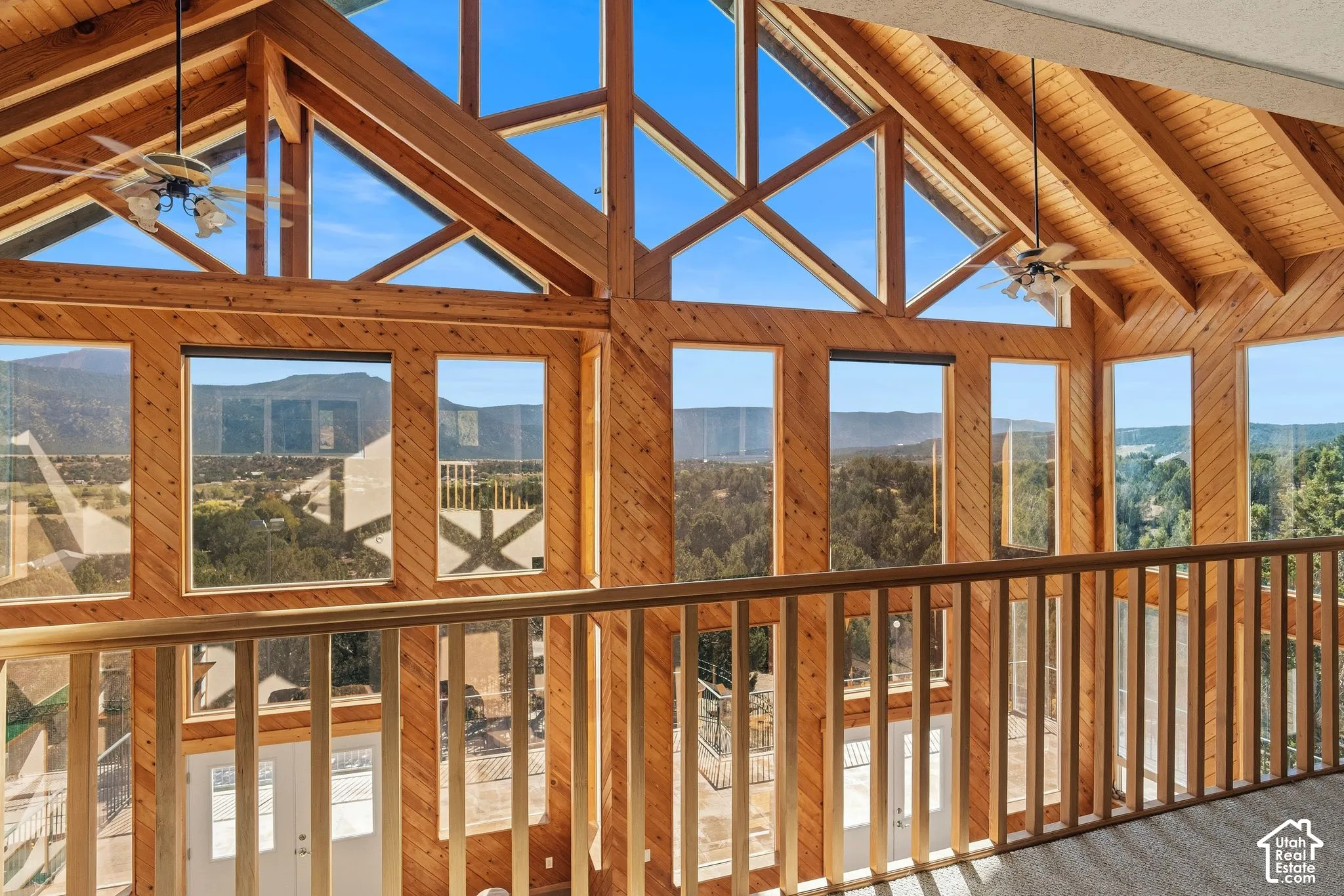 Soaring vaulted ceiling with exposed timber beams and expansive transom windows flood this upper-level space with natural light
