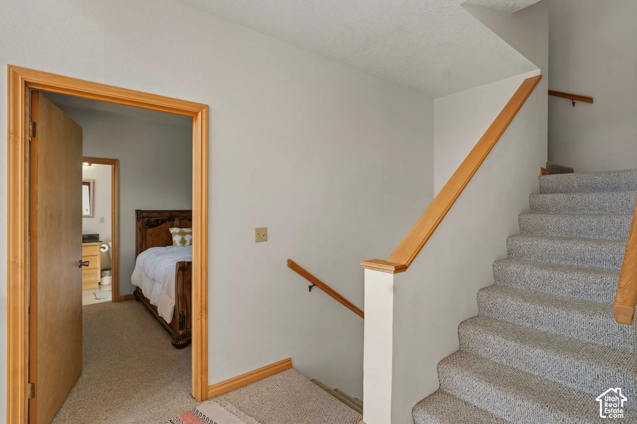 Carpeted staircase with wood handrails