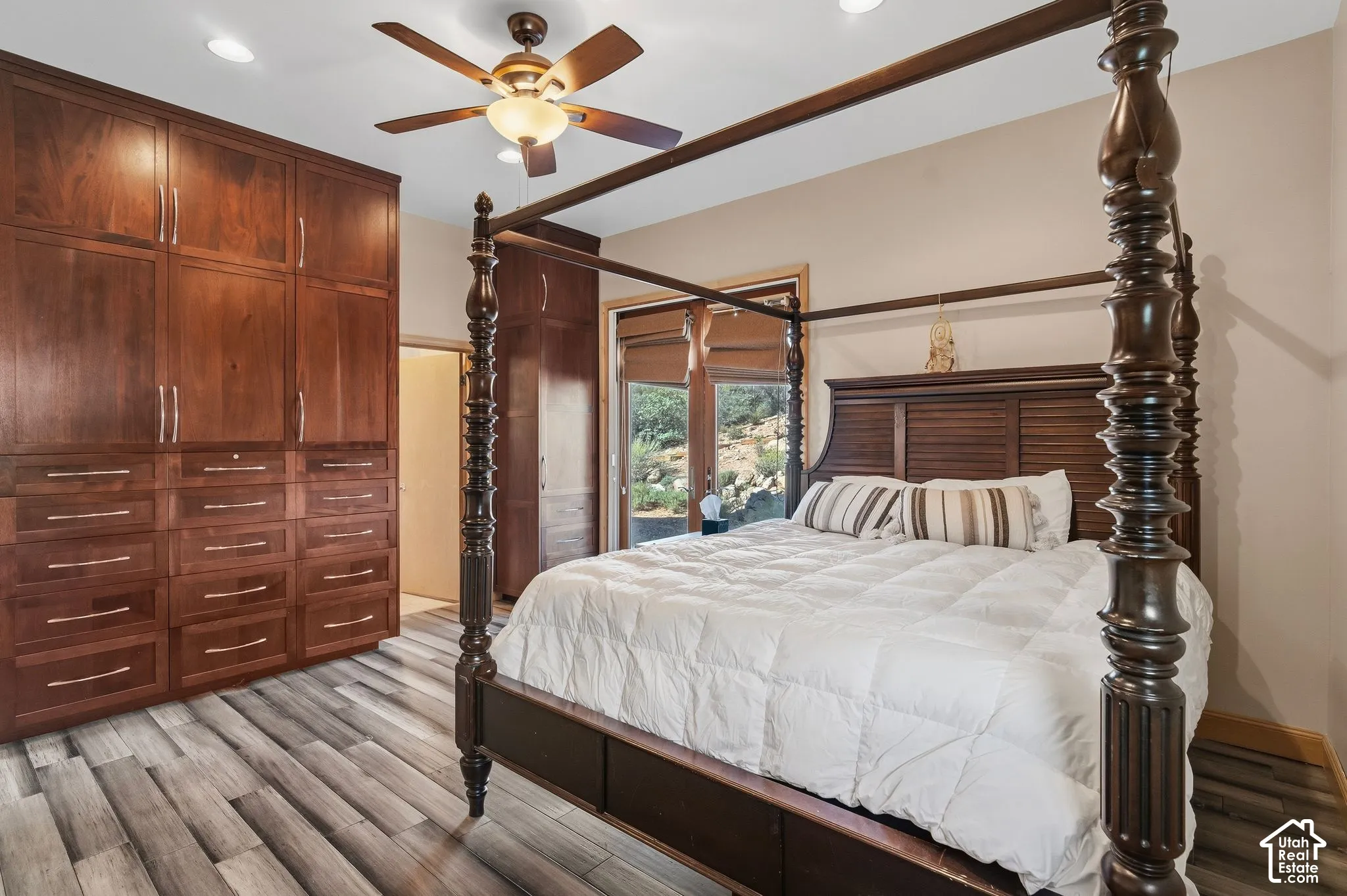 Custom built-in cabinetry, wood-finish flooring, ceiling fan, recessed lighting, and direct outdoor access