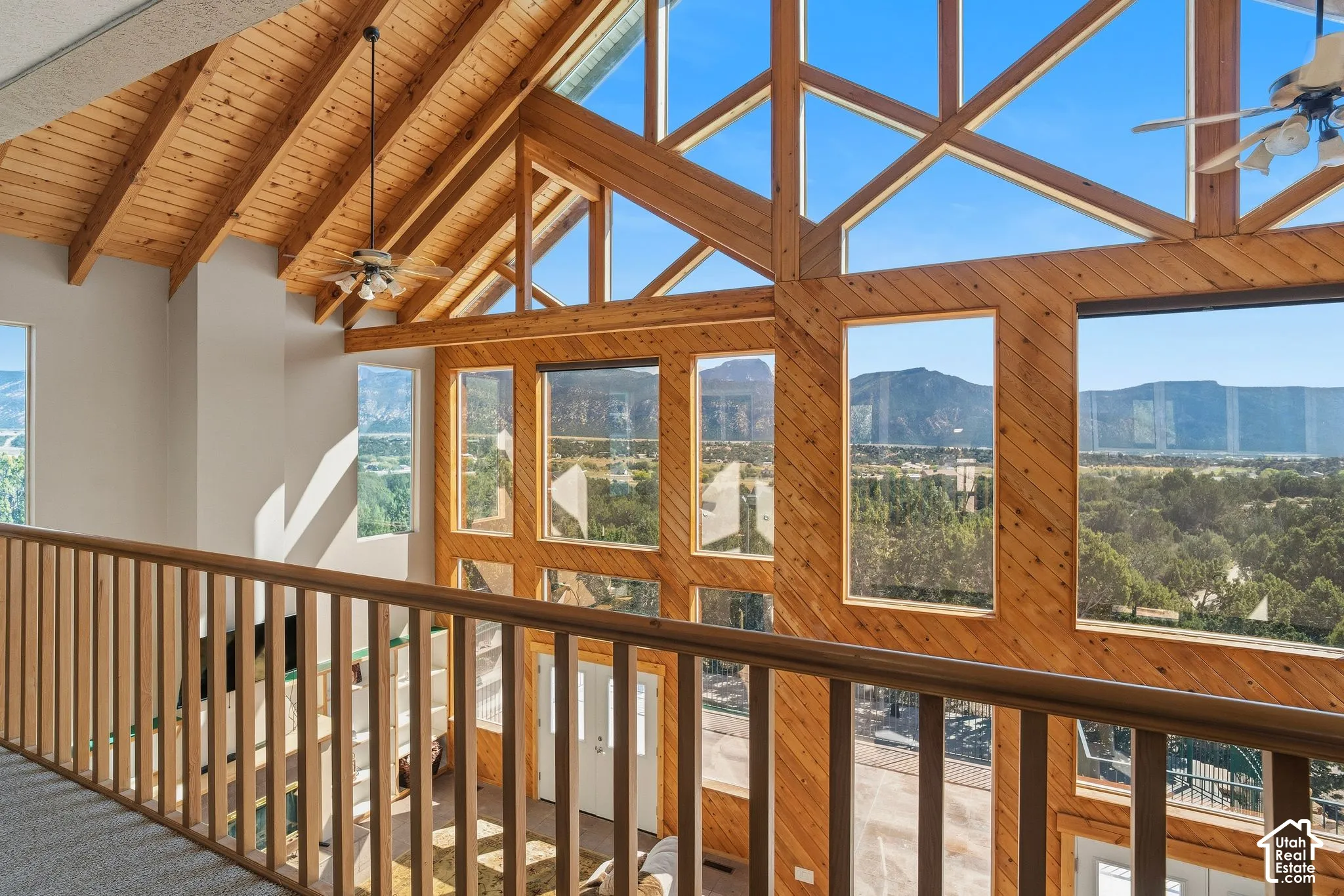 Vaulted wood-paneled ceilings, natural wood beams, and expansive windows showcasing distant mountains and trees