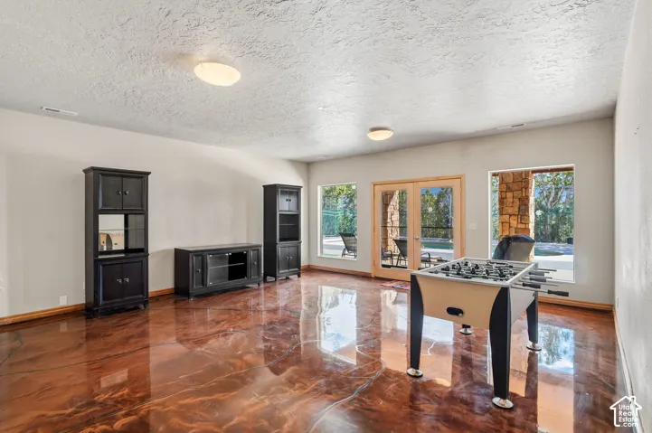 Spacious room featuring glossy, reflective flooring, recessed lighting, and multiple windows