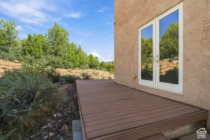 Exterior stucco finish, wood-look decking, and dual full-light patio doors