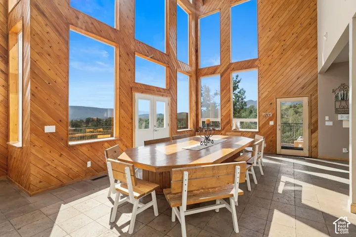 Soaring timber-frame dining room anchored by expansive multi-pane windows framing mountain vistas