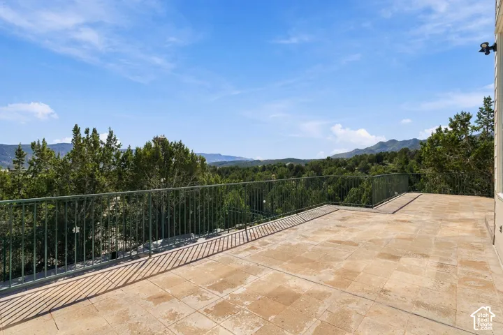 Expansive outdoor patio with tile flooring and a dark metal railing