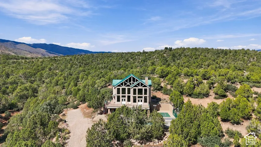 Property featuring a multi-story facade with extensive window arrangements, a prominent A-frame roofline, and a surrounding natural landscape