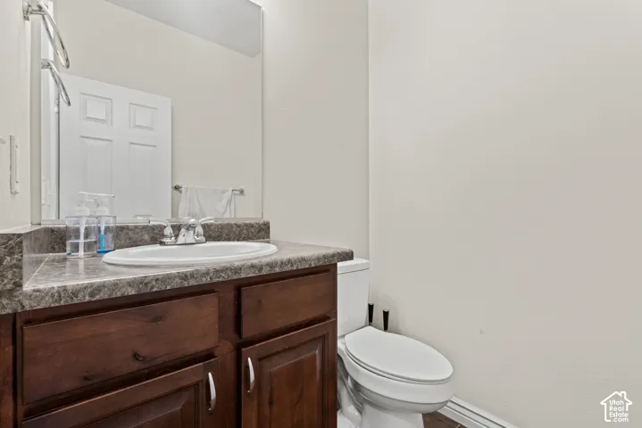 Dark wood-finish vanity with a built-in sink, gray-toned countertop, and a vanity mirror