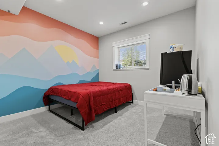 Carpeted room featuring a decorative wall mural, recessed lighting, and a white framed window