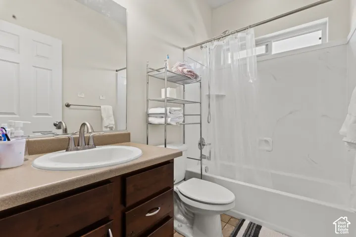 Bathroom vanity featuring a single basin sink, brushed nickel faucet, and wood-finish cabinetry