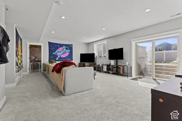 Recessed lighting illuminates this carpeted room with light gray walls