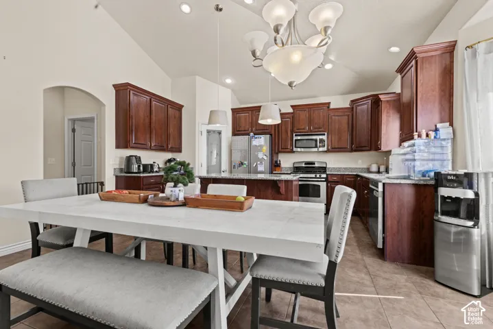 Vaulted ceiling with recessed lighting and a decorative chandelier, dark wood cabinetry, and a light-toned countertop