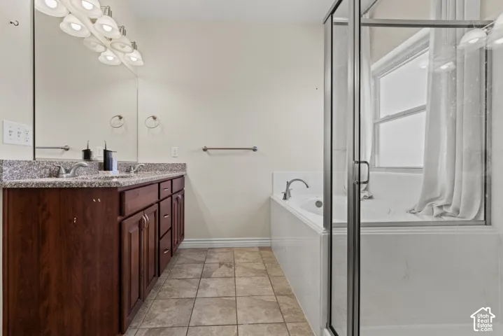 Double vanity with granite-style countertop, undermount sinks, and wood cabinetry