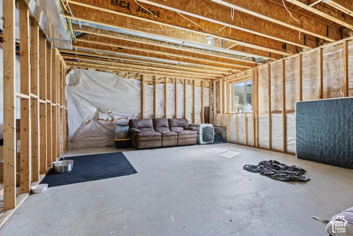 Unfinished basement with exposed wood framing, concrete flooring, and exposed ceiling joists