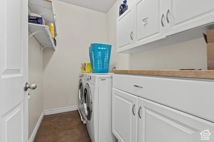 White shaker-style cabinetry with chrome hardware, wood-finish countertop, and integrated laundry appliances