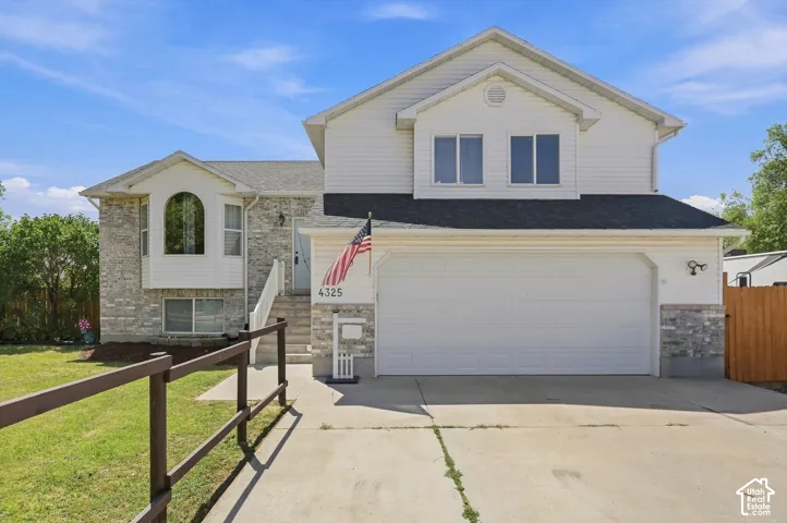 Two-story residence featuring a composite stone and siding exterior with a two-car attached garage