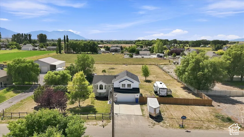 Spacious residential property situated on expansive grounds with mature landscaping, including established trees and manicured lawn areas