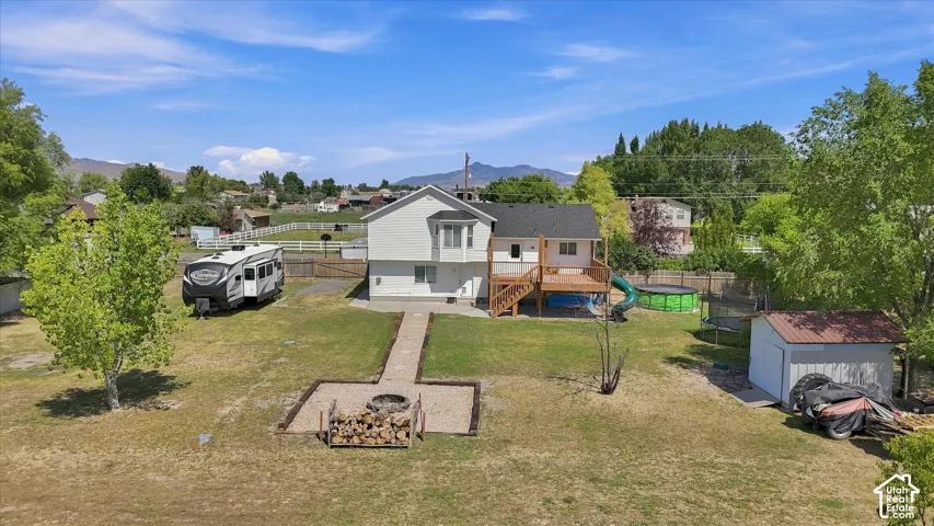 Spacious residential property situated on expansive grounds with mature landscaping, a detached garage, and multiple outbuildings