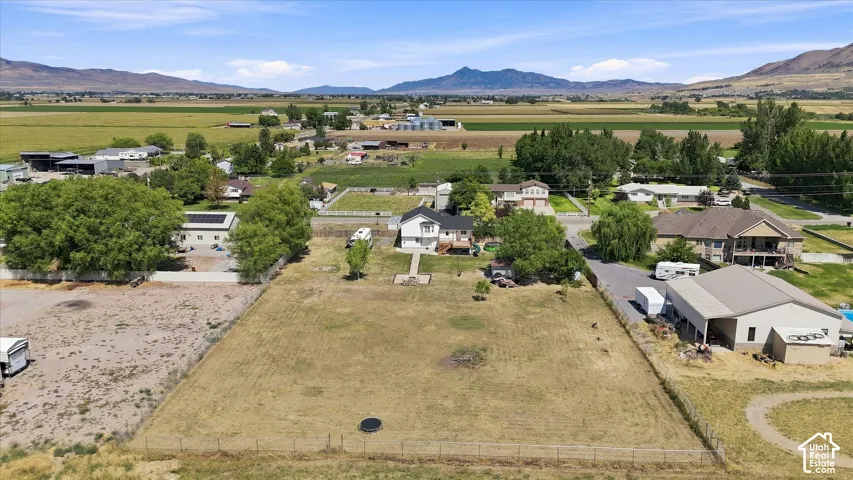 Expansive rural property featuring multiple outbuildings, mature landscaping with established trees, and open acreage with mountain vistas