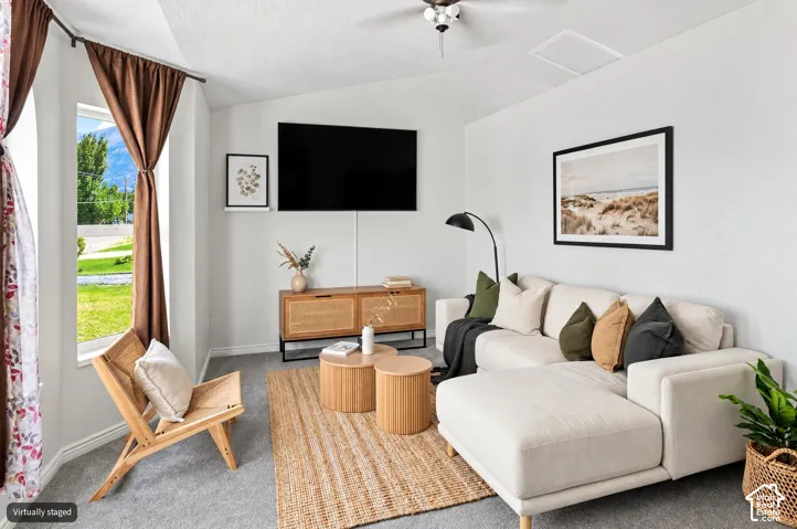 Vaulted ceiling with a ceiling fan, bay window, wall-mounted television, and carpeted flooring