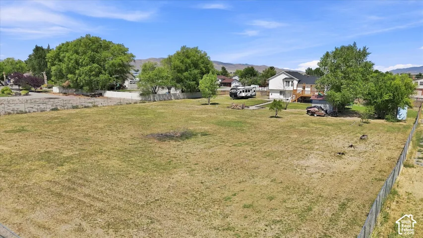 Expansive grounds featuring a level, grassy pasture with mature shade trees and wooden perimeter fencing