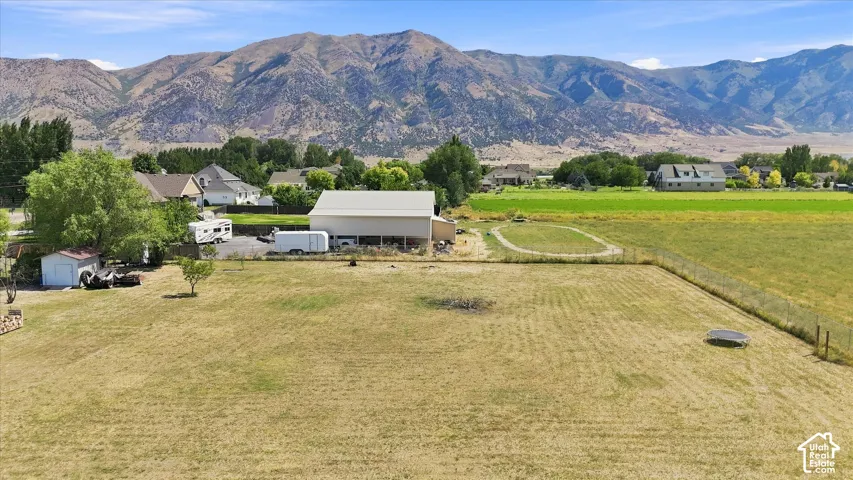 Expansive property featuring a large barn structure, separate storage shed, and mature trees
