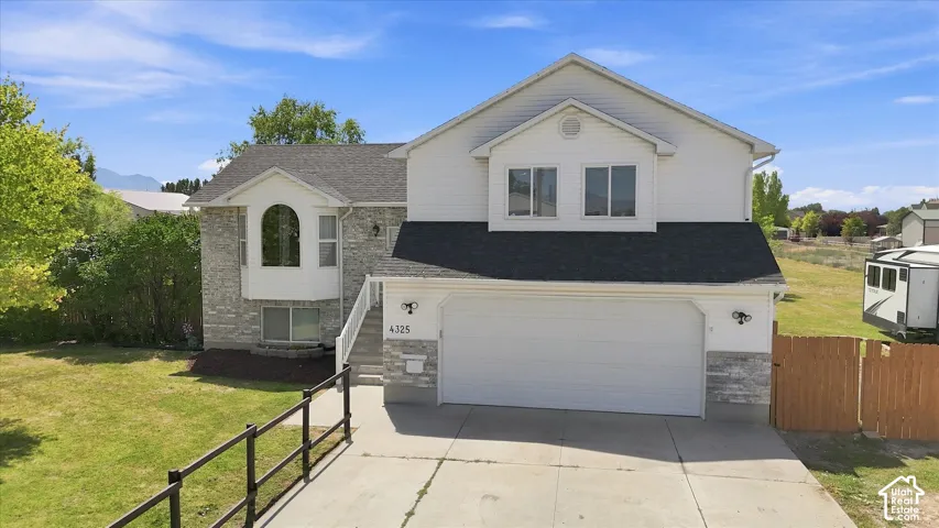 Two-story residence featuring a stone and siding exterior, an attached two-car garage, and a concrete driveway