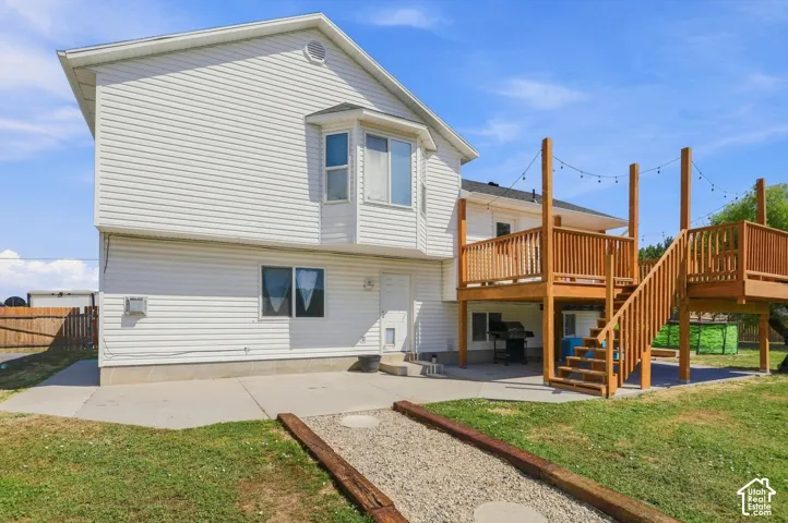 Modern two-story residence with crisp white vinyl siding and peaked roofline, complemented by a spacious concrete patio