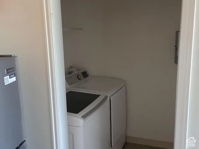 Built-in laundry closet with a wire shelf and hard-surface flooring