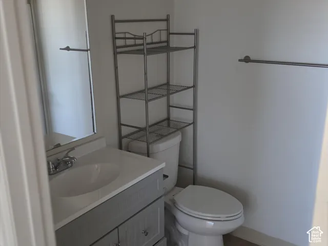 White vanity with integrated sink, chrome faucet, and rectangular mirror