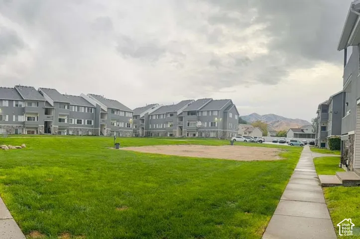Expansive green space featuring manicured lawn and a gravel area