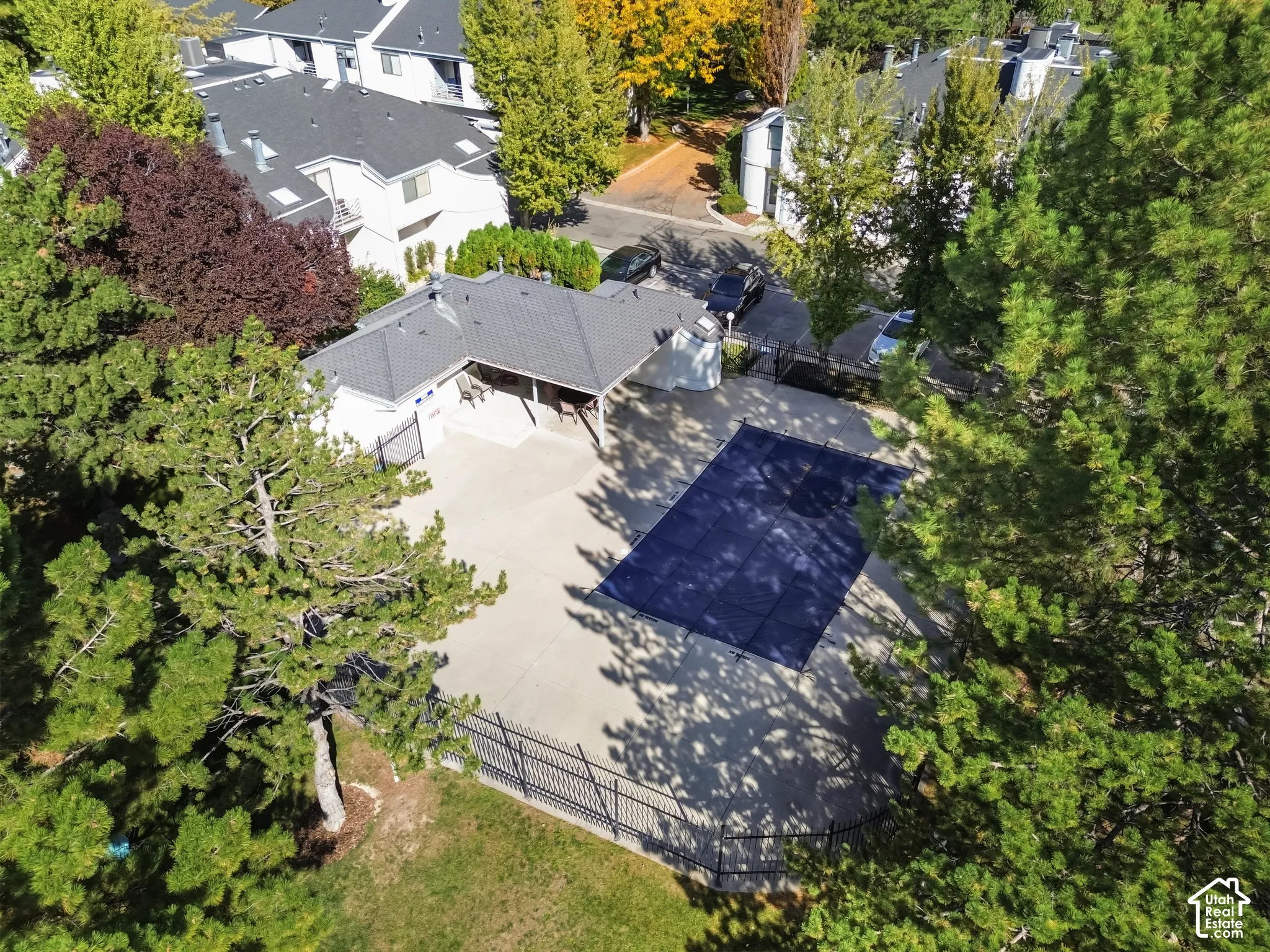 Expansive aerial view showcasing the residence nestled within mature landscaping and tree coverage