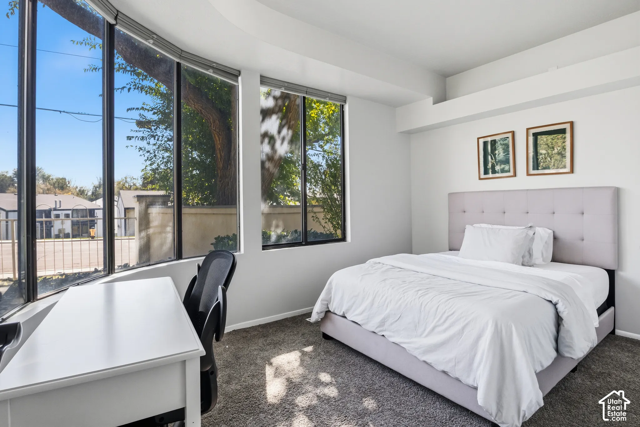 Curved bay window, multiple large windows with roller shades, recessed lighting, and carpeted flooring