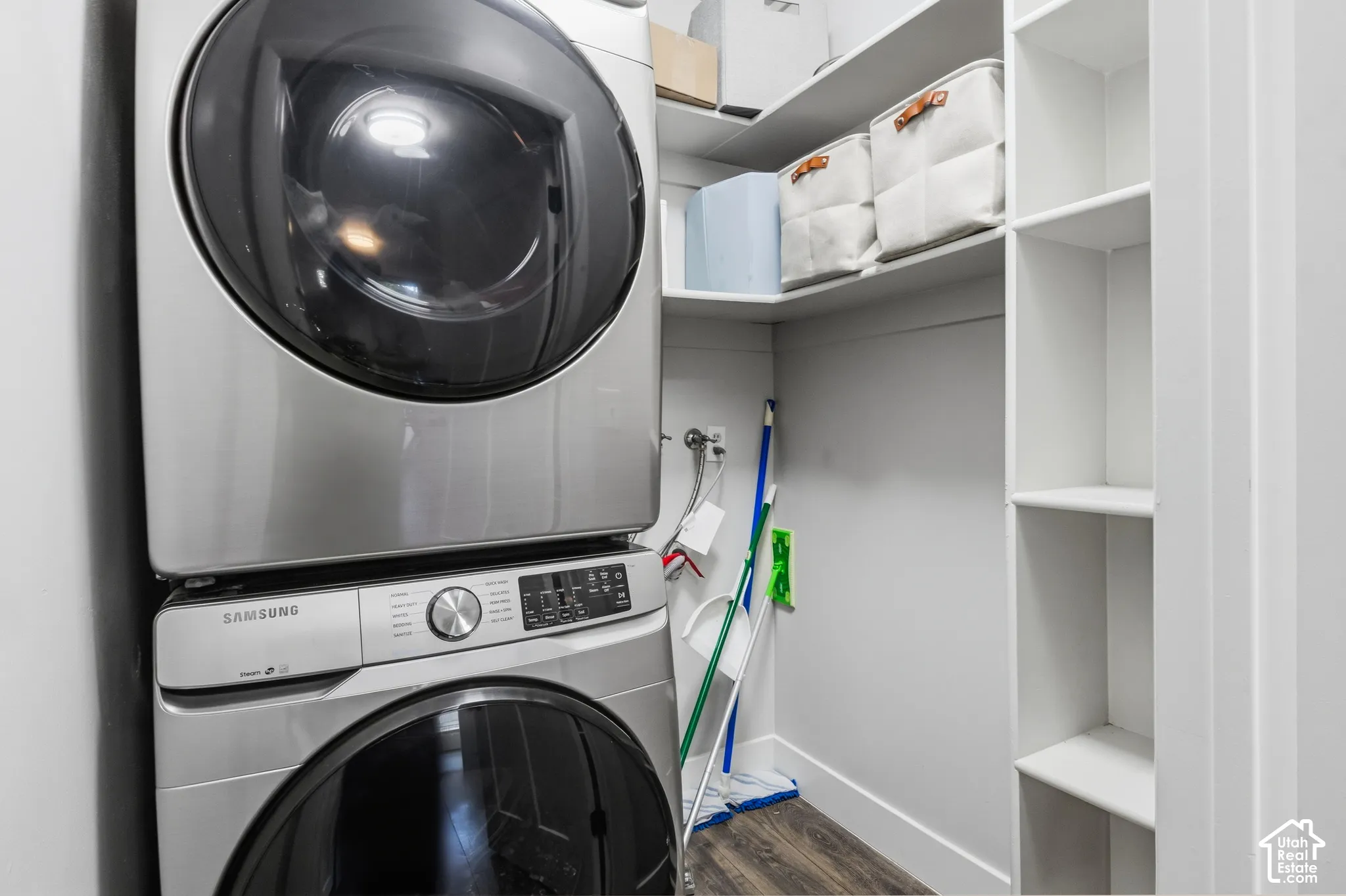 Stackable washer and dryer unit, built-in shelving, wood-finish flooring