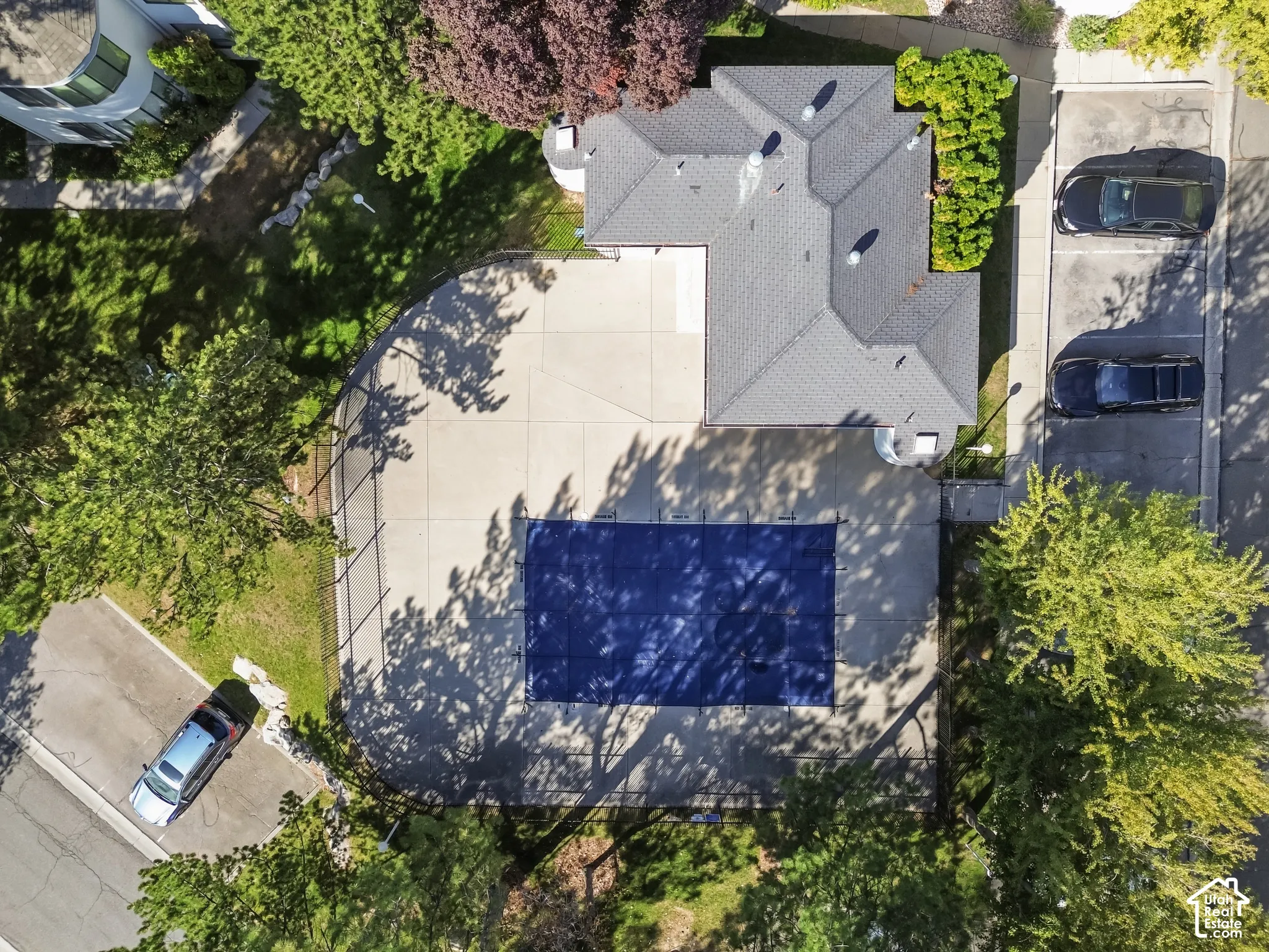 Shingled roofline, paved parking area, and a covered pool